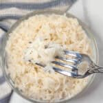 Instant Pot basmati rice in a fork over a bowl of rice.