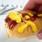 Fully loaded air fryer hot dog with mustard and ketchup on it.