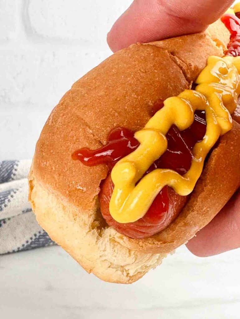 Air fryer hot dog with mustard and ketchup.