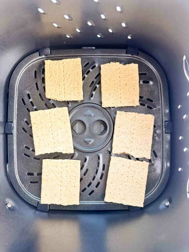 Graham cracker squares in the basket of an air fryer.